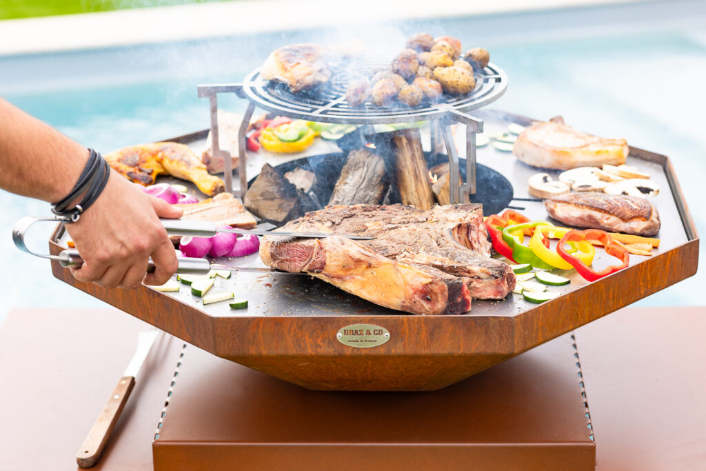 Service d'une côte de porc cuisinée sur un brasero plancha